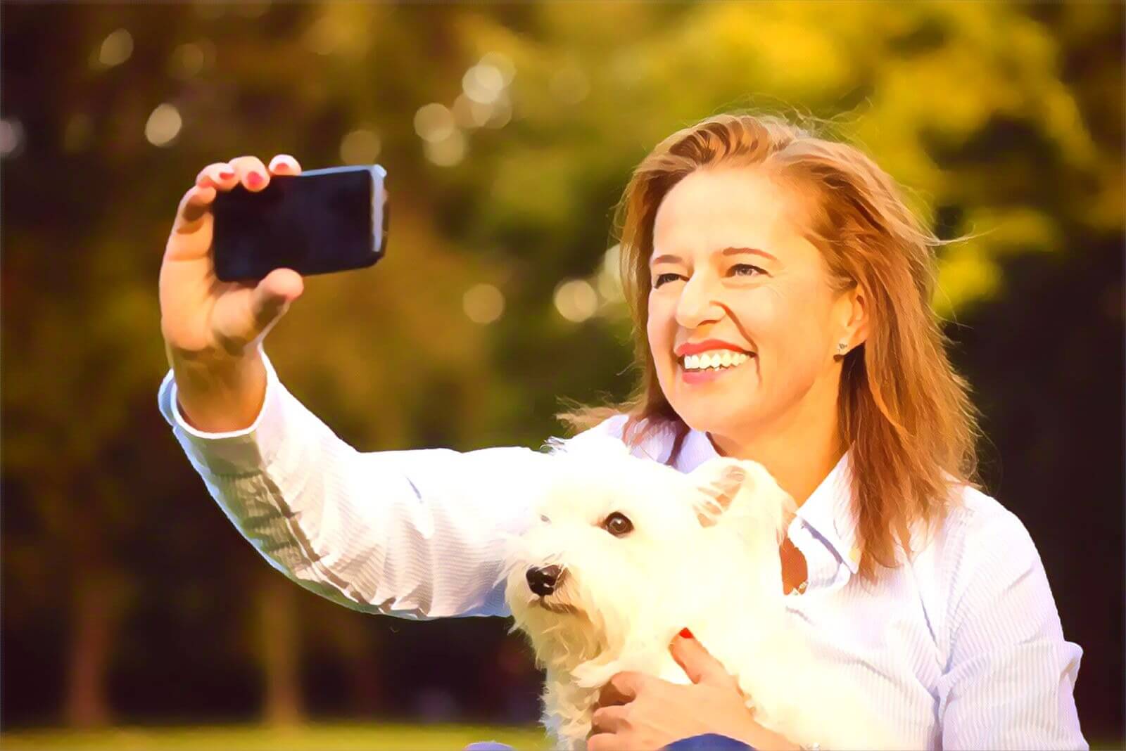 Woman holding dog and taking pictures of herself